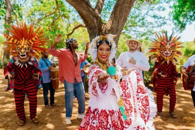 Celebración cultural panameña con pollera nacional, diablicos sucios y música folclórica al aire libre