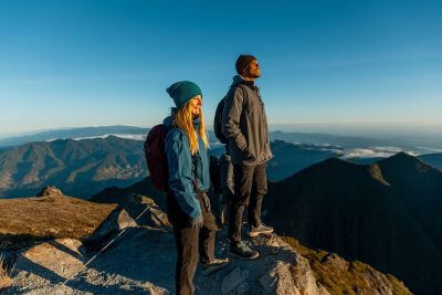 Pareja haciendo senderismo en la cima del Volcán Barú, Panamá, con vistas panorámicas a las montañas